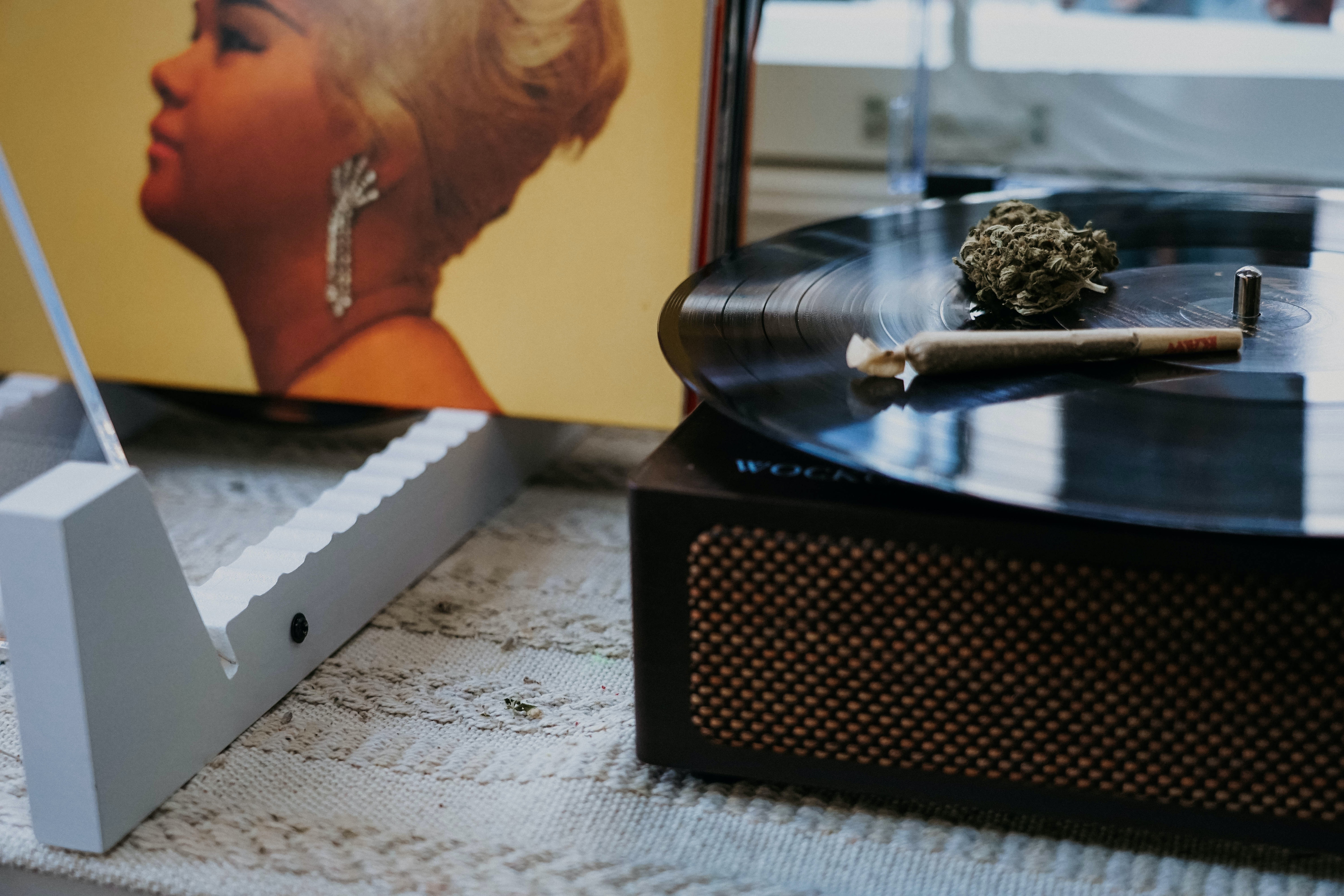 an etta james record sitting next to a turntable with a blunt sitting on top